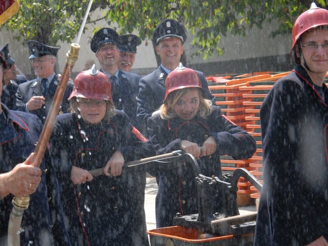 Feuerwehrler mit alter Löschspritze