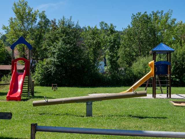 Holzwippe, Klettertürme mit Rutschen im Hintergrund