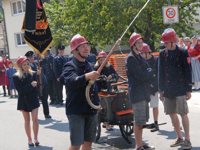 4 Menschen schieben eine alte Feuerlöschmaschine 