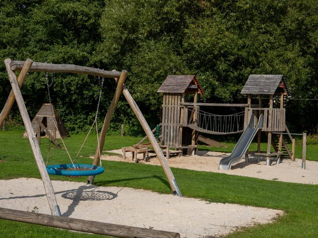 Nestschaukel, im Hintergrund der Kletterturm mit Hängebrücke und das Tipi