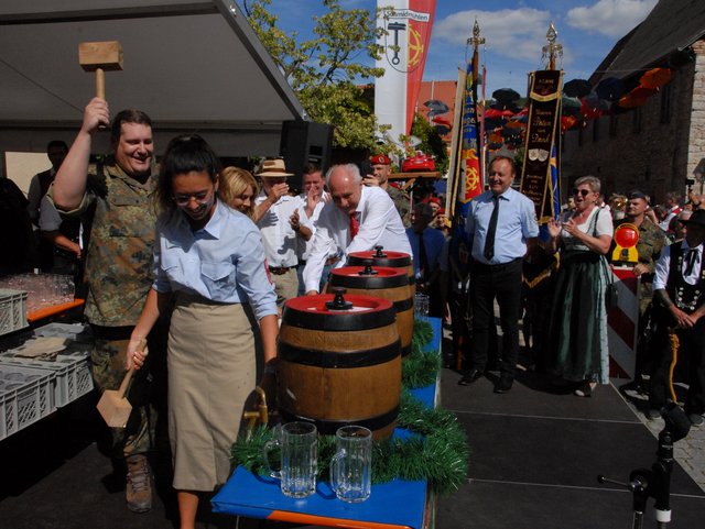 Bieranstich viele Personen um ein Fass