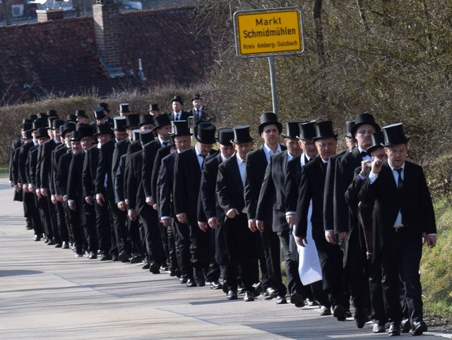 Männer in Reih und Glied in Frack und Zylinder